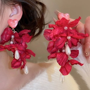 Detail von roten Stoffblumen-Ohrringen mit Perlen und rosa Herzstecker am Modell