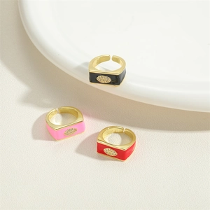 Three square enamel evil eye rings in black, pink, and red with gold-plated metal finish