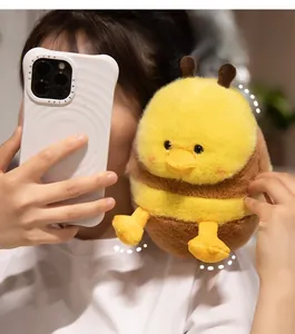 Detail of cute bee-duck plush keychain held by hand for lifestyle decoration
