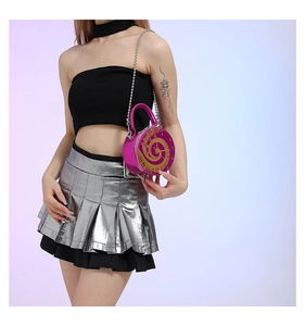 Detailed close-up of pink round handbag with gold clock face design and chain strap