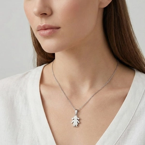 Close-up of a polished silver girl-shaped pendant necklace worn by a female model