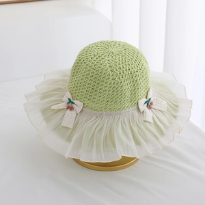 Detail of child straw hat with white chiffon brim and cute cherry bow decorations