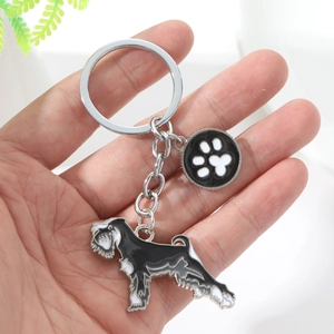 Detail of silver alloy keychain with Schnauzer dog and paw print enamel charms
