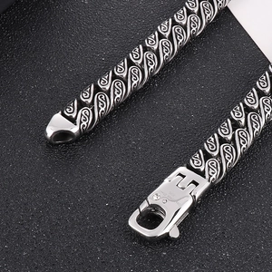 Macro view of 316L stainless steel woven chain necklace with engraved spring clasp