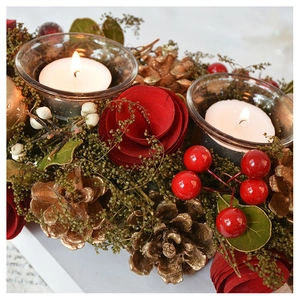 Detailed view of Christmas candle holder with red roses, gold pinecones, and glass cups