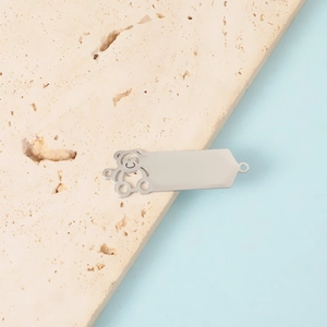 Polished silver stainless steel hollow bear pendant and bar connector on stone base