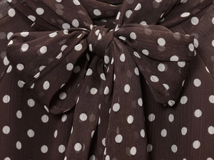 Detailed macro view of brown polka dot chiffon fabric texture and bow neck tie design