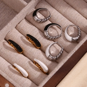 Detail of tear-drop enamel earrings and twisted hoops in gold and silver plating