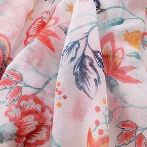 Detailed macro view of lightweight cotton-linen scarf fabric with red pomegranate print