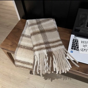 Detail shot of the thick tassels and plaid cashmere-like fabric of the warm winter scarf