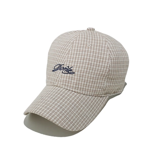 Close-up of blue 'Done' embroidery on a tan and white checkered cotton baseball cap