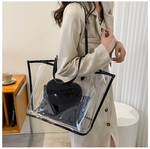 Detailed shot of transparent tote bag with black trim and heart-shaped inner pouch on shoulder