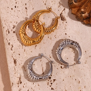 Detail of 18K gold and silver plated hoop earrings with hollow triple stripe texture