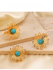 Dettaglio di un anello a fiore vintage in oro con pietra turchese incastonata al centro