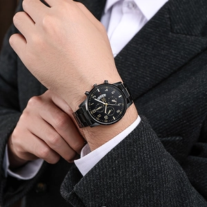 All black men's fashion chronograph watch with stainless steel strap on a suit wrist