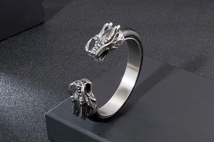 Detail of double dragon head stainless steel leather bracelet on a black display stand