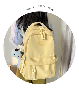 Detailed back view of a minimalist large capacity light yellow backpack with woven zipper pulls
