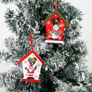 Detail of wooden Christmas tree house ornaments with small golden bells and red satin ribbons