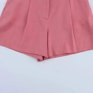 Detail view of pink linen blend shorts showing fine fabric texture and hem stitching