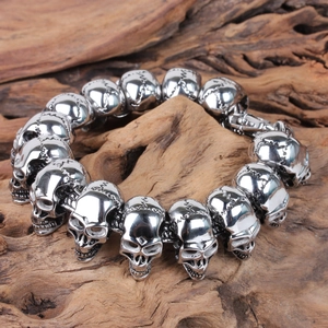 Macro shot of punk style stainless steel skull bracelet links on a rustic wood background
