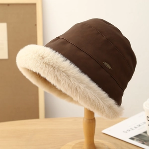 Chapeau bob d'hiver en daim marron avec bordure en fourrure sur support en bois