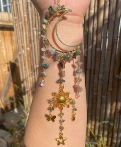 Detail of moon and sun wind chime with natural colorful crystal stones and gold butterfly charms
