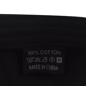 Detailweergave van het 100% katoenen waslabel op deze zwarte baseballpet