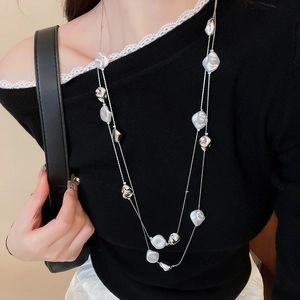 Detail of layered French retro necklace with crystal beads and irregular pearls on model