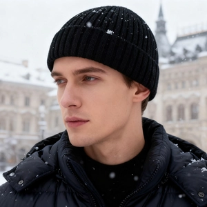 Black ribbed knit beanie for men and women worn by model in a snowy street setting