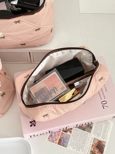 Pink quilted makeup bag with bow embroidery showing large storage for cosmetics