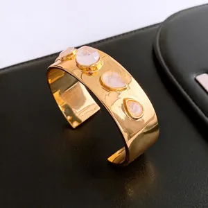 18K gold-plated wide cuff bracelet featuring four pear-cut rose quartz stones on a gold band