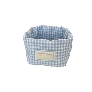 Blue and white checkered quilted fabric storage basket for makeup and desk organization