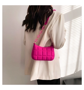 Detail der gesteppten Filz-Schultertasche in Pink mit Kette und cremefarbenem Sakko