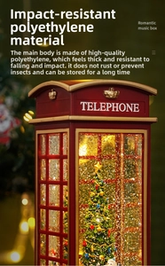 Close-up of red telephone booth music box with interior Christmas tree and golden glitter