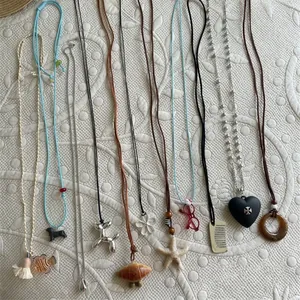 Fashionable creative necklace set with varied pendants on elegant white textured fabric