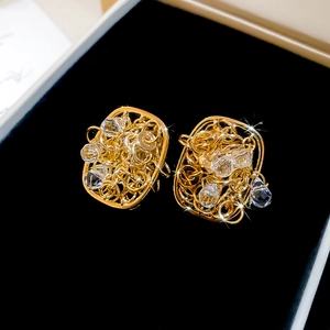 Close-up of 18k gold plated square earrings with crystals on a black jewelry box