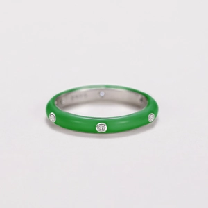 Detailed macro view of green enamel ring with bezel set zircon stones in silver finish