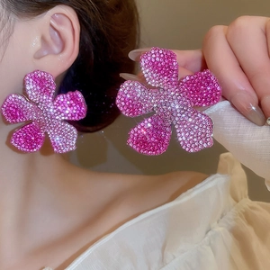 Detail of large flower stud earrings with pink gradient crystals and silver settings