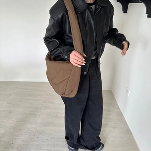 Brown quilted puffer crossbody tote bag styled with a leather jacket and wide-leg trousers