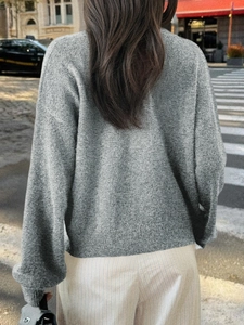 Vue arrière d'un pull en maille gris ample et décontracté avec ourlet côtelé en rue