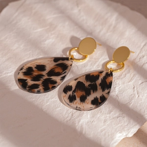 Detailed view of leopard print teardrop earrings with golden circular metal studs