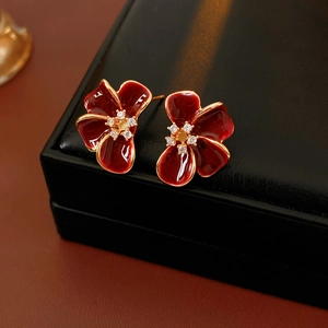 Close-up of vintage red enamel flower earrings with gold plating and zircon details