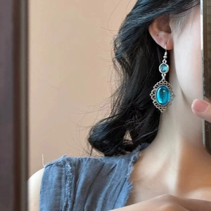 Vintage bohemian earrings featuring blue oval resin pendants and intricate silver lace