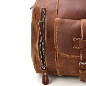 Detail of vintage brown leather bag with side zipper pocket and metal belt buckle design