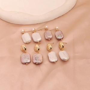 Detail view of baroque pearls with golden metal studs on pink silk and plaster decor