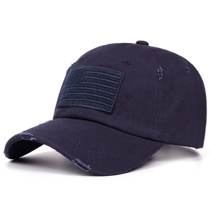 Close-up detail of a navy blue distressed baseball cap featuring a USA flag patch