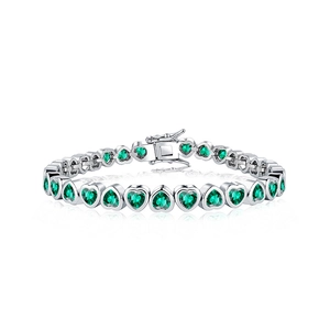 Macro shot of heart-shaped green zircon tennis bracelet in polished silver setting