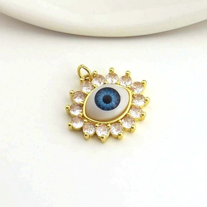 Detail of 18k gold plated evil eye pendant with blue zircon stones and inlay craftsmanship
