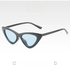 Detail of vintage cat-eye sunglasses with black glossy frames and light blue lenses