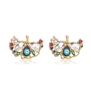 Macro view of gold-plated evil eye stud earrings with colorful zircon wing details